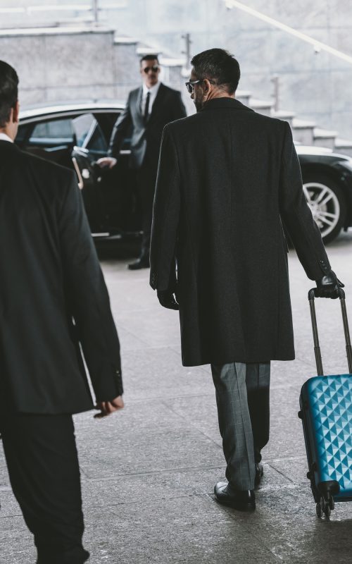 businessman-going-with-blue-travel-bag-to-car.jpg